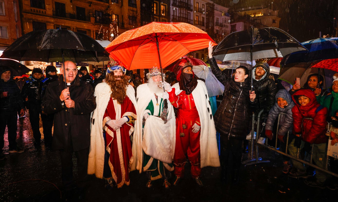 Los Reyes se cobijan de la lluvia bajo un paraguas al llegar al Ayuntamiento