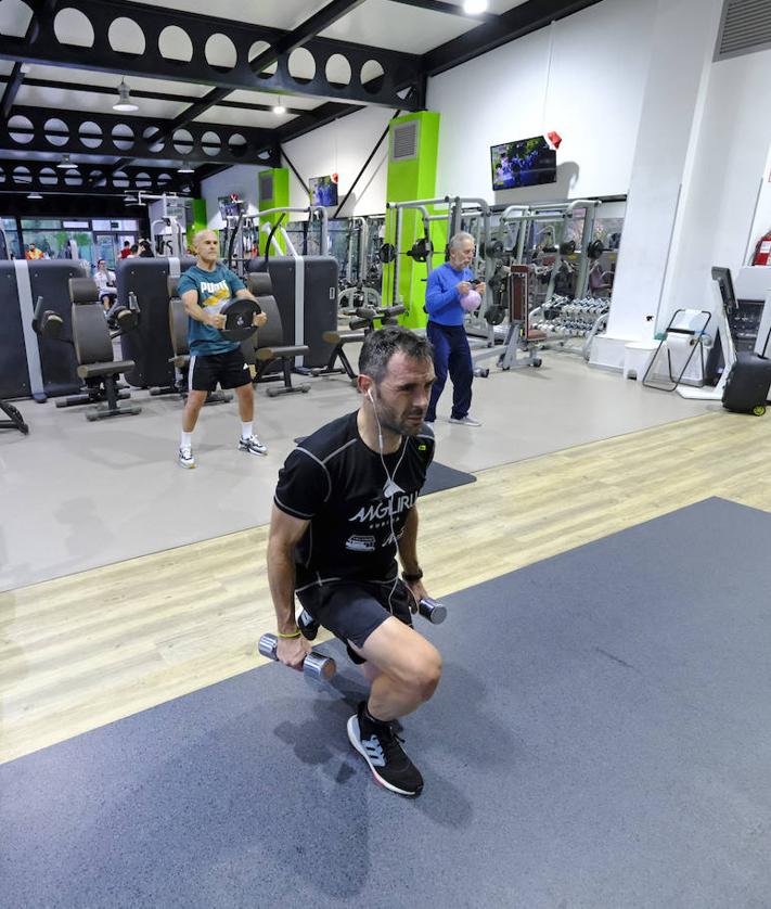 Imagen secundaria 2 - 1. Los socios practican deporte en la sala de máquinas. | 2. Un usuario realiza ejercicios de fuerza.