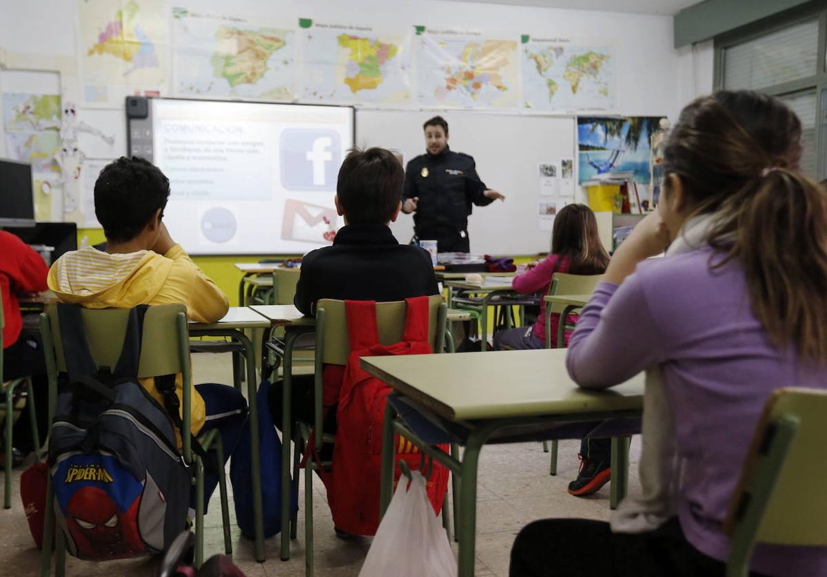 Un agente de policía imparte una charla en un aula sobre la prevención del acoso escolar.