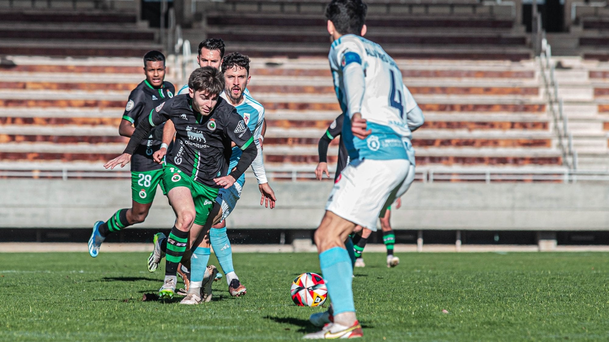 Diego Fuentes intenta controlar el balón ante varios jugadores del Compostela.