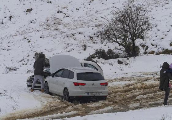 Un vehículo detenido ante el mal estado de una carretera llena de nieve.