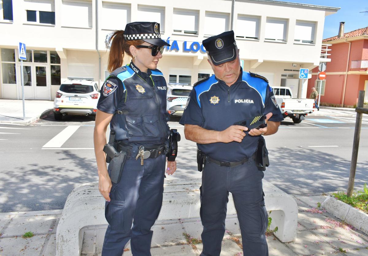 Dos policías de Los Corrales de Buelna frente a las instalaciones del cuerpo.