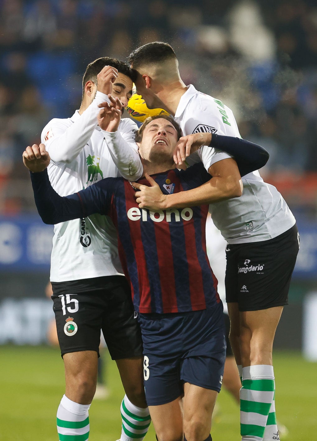 Rubén Alves y Pol Moreno, del Racing, saltan en un córner con Bautista, del Eibar