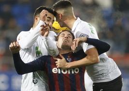 Rubén Alves y Pol Moreno, del Racing, saltan en un córner con Bautista, del Eibar.