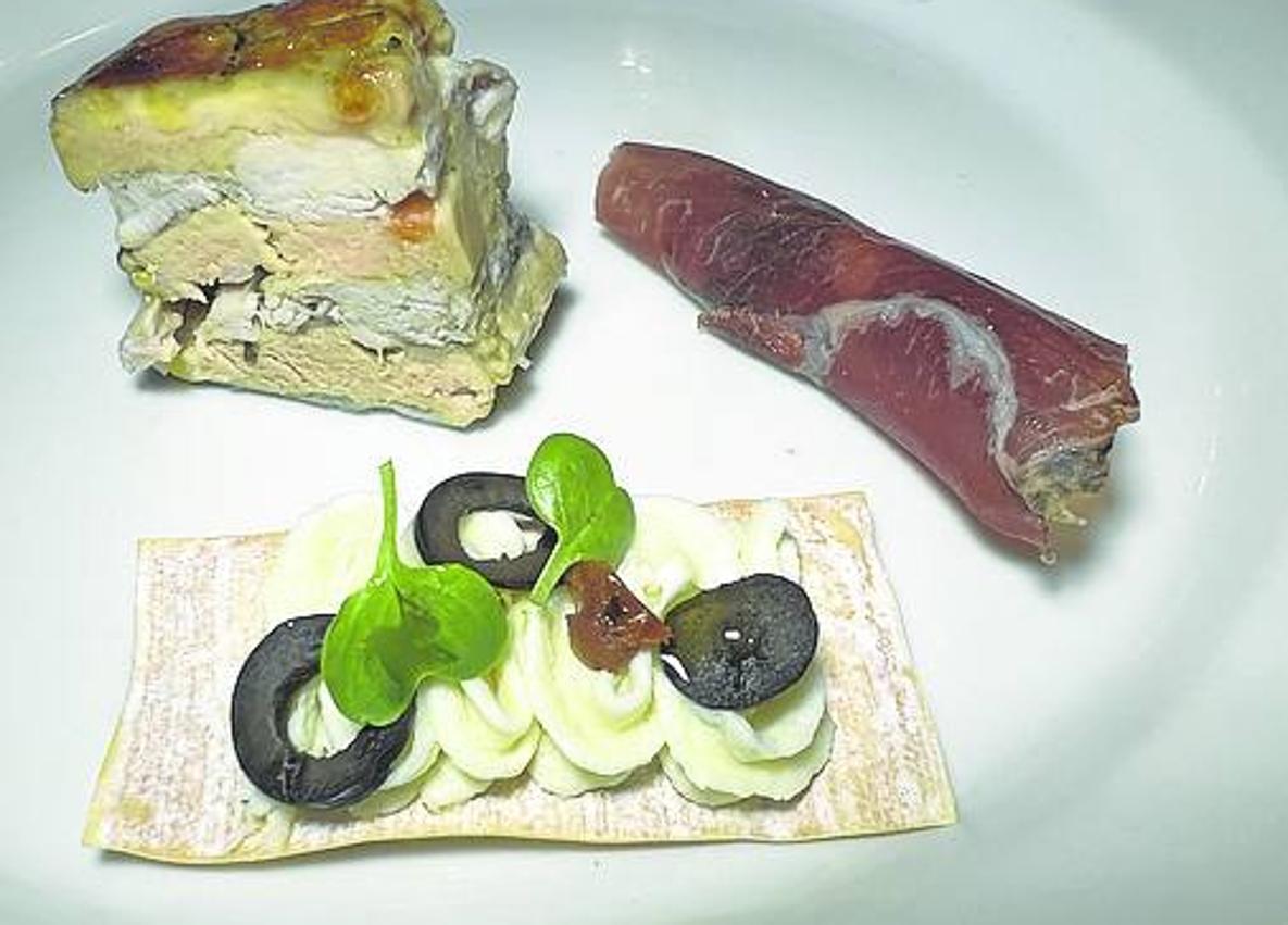 Imagen secundaria 1 - Arriba, puerros confitados con vinagreta de pimientos. A la izquierda, foie, cecina y brandada, tres aperitivos. Y, a la derecha, buñuelos de mejillón tigre. 