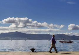 Un hombre pasea frente a la bahía de Santander.