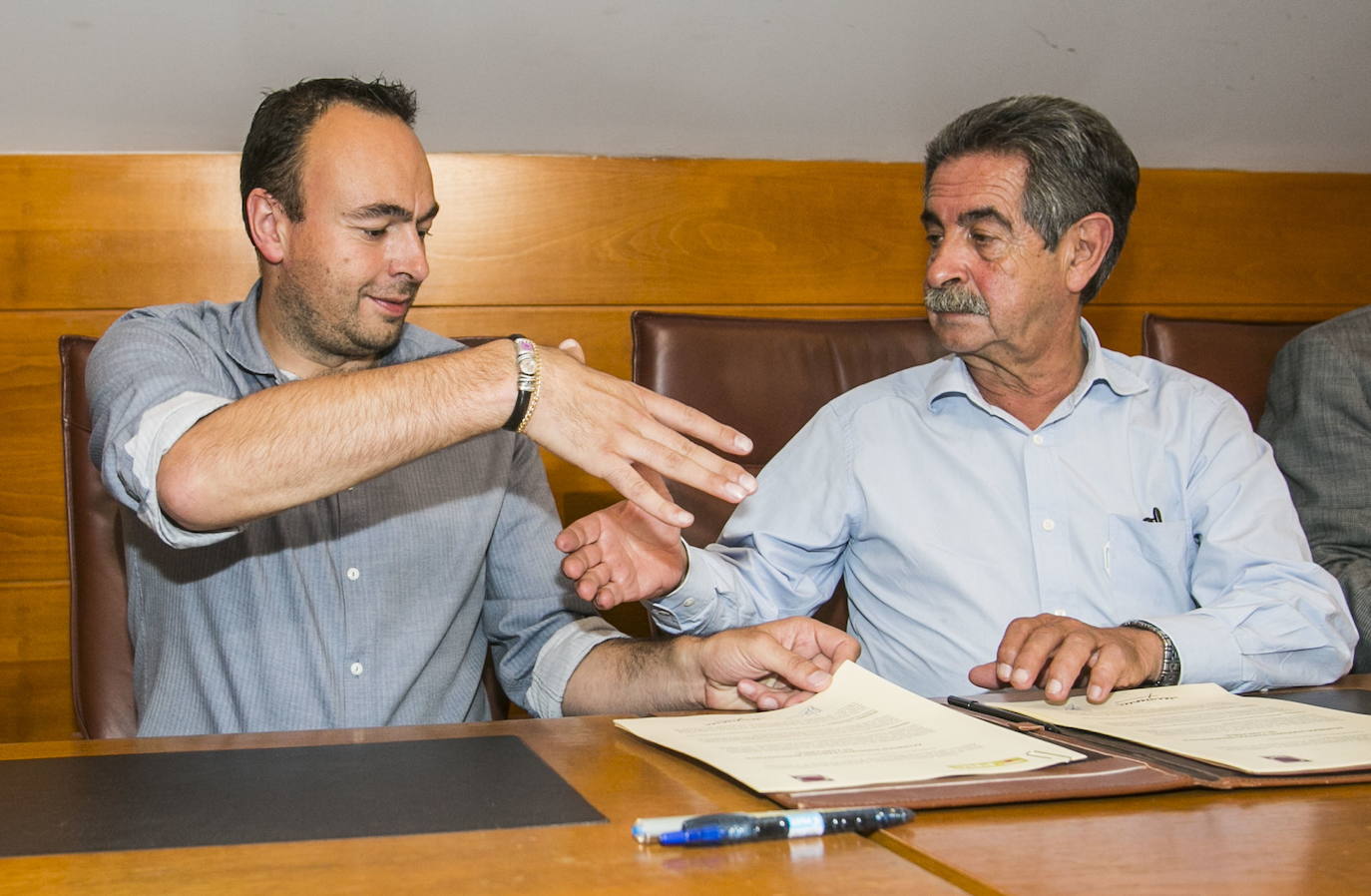 Firma del acuerdo Podemos-PRC para investir presidente a Miguel Ángel Revilla. Un pacto que le costó su escaño a Javier Marcano. En la foto, José Ramón Blanco y Miguel Ángel Revilla se dan la mano tras firmar el documento.