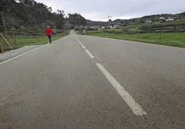 Un hombre atraviesa la carretera entre el barrio de La iglesia y Ruilobuca, por donde discurrirá la senda.