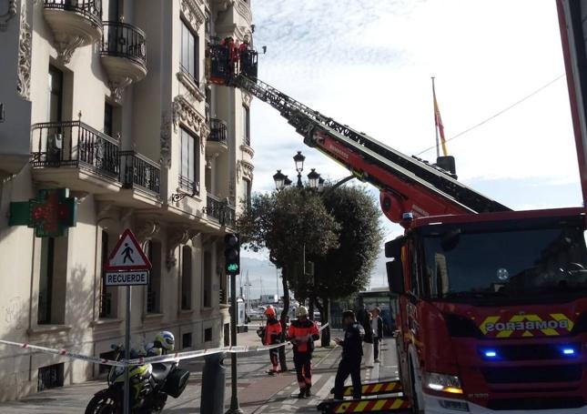 Imagen del momento en el que los Bomberos de Santander intervienen con una grúa para retirar los cascotes