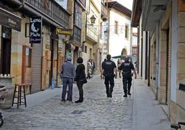 Dos agentes atraviesan una de las calles del casco urbano de la villa.