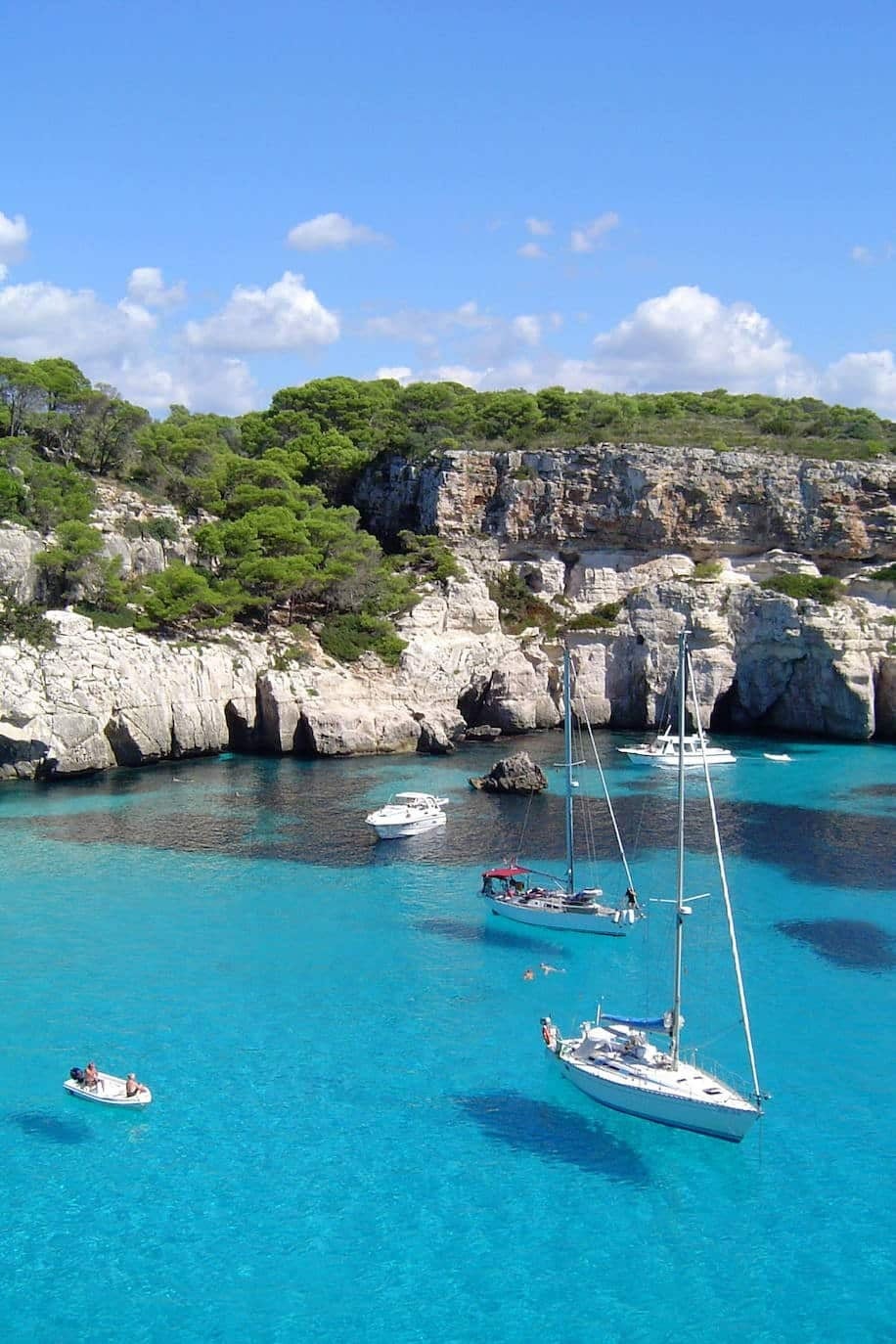 A estas idílicas calas menorquinas solo se puede llegar por mar o a pie. Juntas conforman uno de los conjuntos más fotogénicos de las Baleares, con sus aguas claras enmarcadas por acantilados cubiertos de pinos que parecen a punto de caer al mar. Aunque en verano son muy frecuentadas, a primera hora del día permanecen tranquilas.