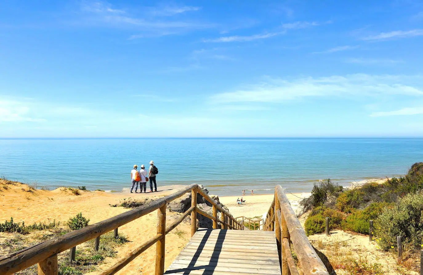 Saliendo en línea recta desde el Puerto Deportivo de Mazagón se tiene por delante una buena quincena de kilómetros de playas de arena fina sin ningún tipo de interrupción que dan idea visual de cómo ha ido evolucionando con el pasar del tiempo este litoral. Desde las zonas más urbanizadas de Mazagón hasta enfilar Moguer y Almonte, a las puertas del Parque de Doñana, se encuentran las playas más salvajes de Huelva. Una de ellas es la Playa de Cuesta Maneli (o playa El Aspillero), en Almonte. Para Viajes National Geographic destaca por lo escénico del camino de llegada, una pasarela de madera que discurre desde el aparcamiento y que acaba en unas escaleras que van a dar en la arena. Aquí el protagonismo es tanto del mar como del Monumento Natural Acantilado del Asperillo, un sistema de dunas fósiles que se extienden a lo largo de doce hectáreas de costa, con unas características geomorfológicas de lo más singulares. Apta para quienes busquen una playa en un entorno de lo más natural.