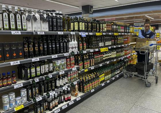 Una dependienta colocaba ayer el sistema de alarma en las botellas de aceite de oliva, en un supermercado BM.