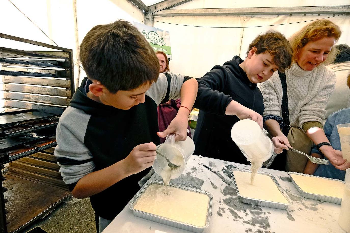 Dos niños preparan su propio queso fresco en uno de los talleres