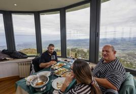 Aarón Rueda (a la izquierda ) disfruta de la comida junto a su madre, Mercedes García, y su padre, Juan, ayer, en el comedordel restaurante de Peña Cabarga.