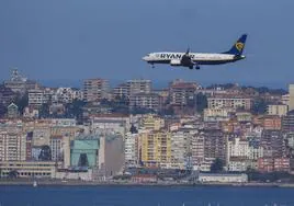 Un avión de Ryanair vuela con Santander al fondo.