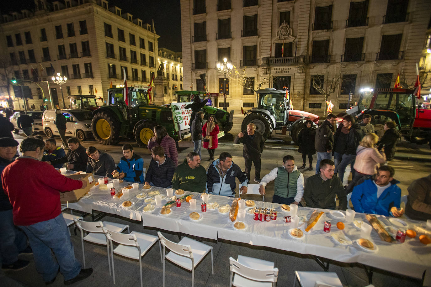 Un grupo de agricultores cenan en plena calle de Santander.