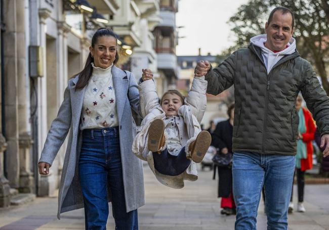 Julia juega con sus padres, Patricia y Sergio, por las calles de Torrelavega.