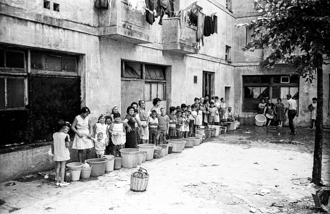 Gentes del barrio en la colas para almacenar el agua.