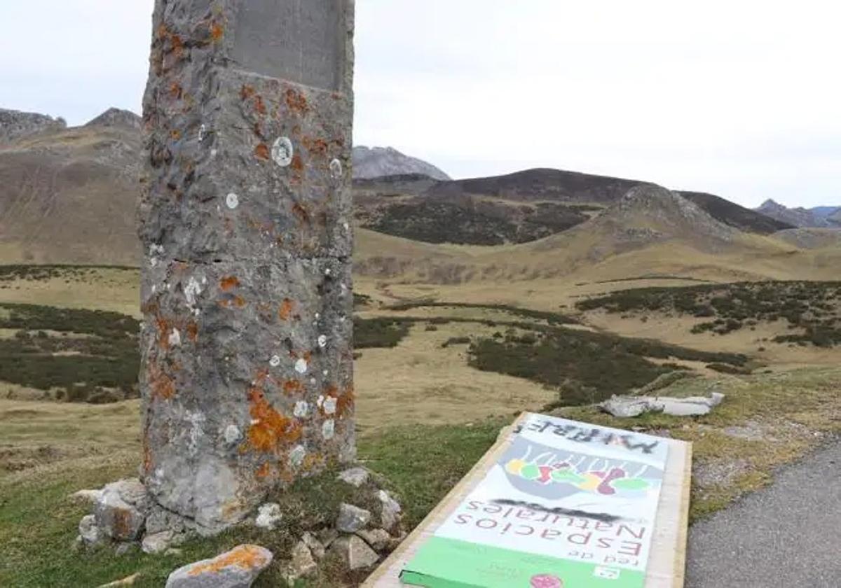 El cartel de León permanece en el suelo junto al monolito en honor al alcalde de Mieres que adquirió los terrenos.