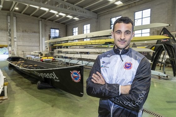 Luismi Villar posa junto a la trainera en la nave de Pedreña.