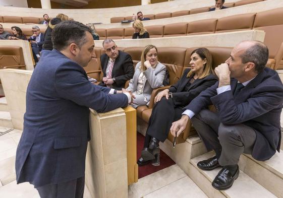 La presidenta de Cantabria, Sáenz de Buruaga, conversa en el Parlamento con sus compañeros de Gobierno.