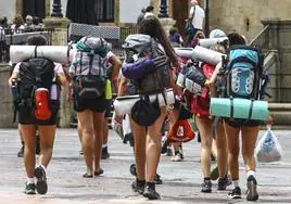 Peregrinos cargan con su equipaje en el Camino de Santiago.