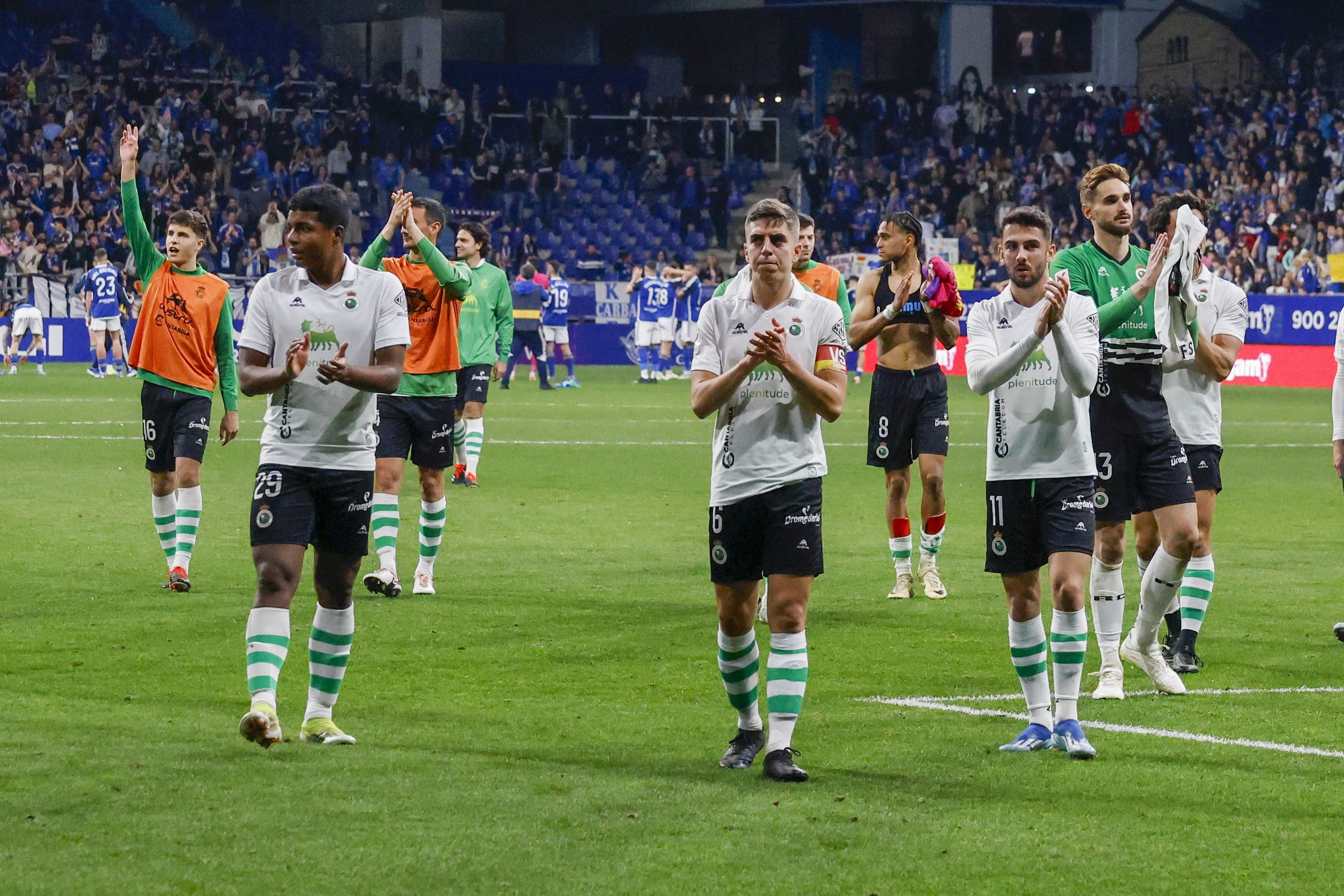 Los jugadores del Racing aplauden para celebrar el empate con los aficionados que se desplazaron hasta el Carlos Tartiere. 