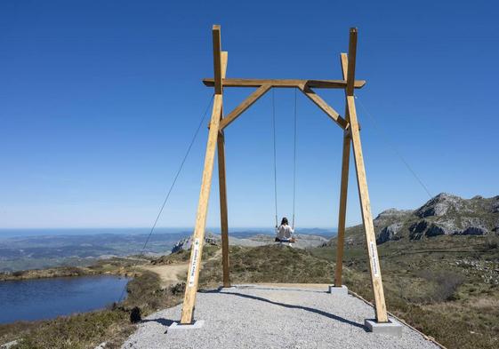 Una mujer disfruta del columpio gigante de los Pozos de Noja, en Miera.