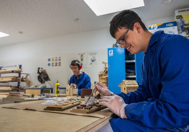 Dos alumnos practican en el taller de madera.