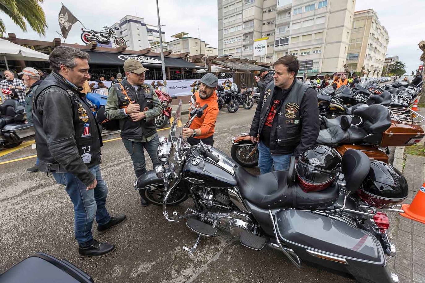 Uno de los participantes muestra su moto a otros tres moteros.