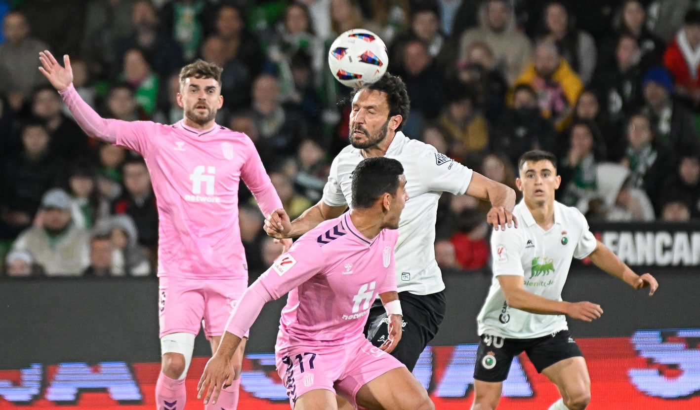 Germán salta para cabecear la pelota con el exracinguista Mario Soberón tras él. 