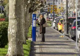 Una mujer paga la OLA en un parquímetro del Paseo de Pereda de Santander.