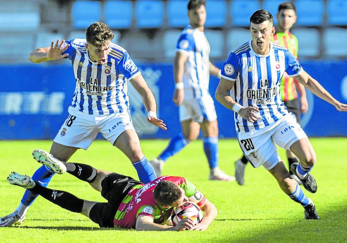 Marcos Fernández y Edu Bedia, de la Gimnástica, frente a un jugador del Villalbés.