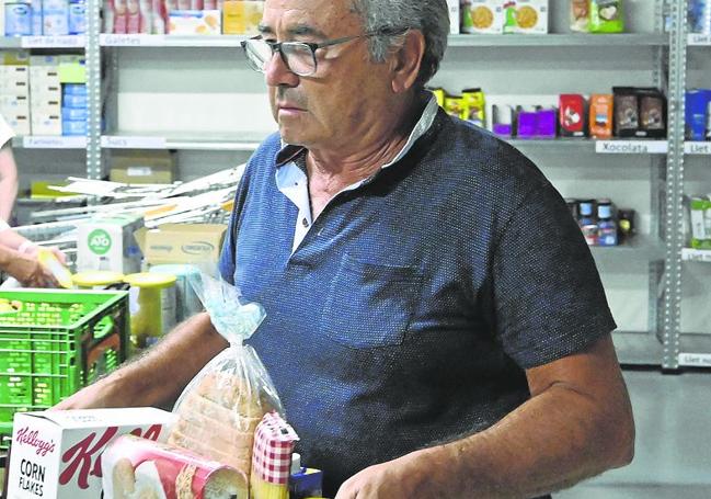 Un voluntario prepara lotes de alimentos.