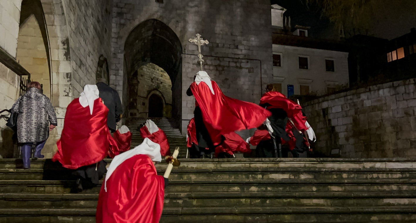 Los cofrades con sus capas al viento a su llegada a la Catedral.