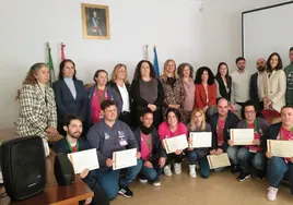 Foto de familia de autoridades locales y alumnos con sus diplomas.