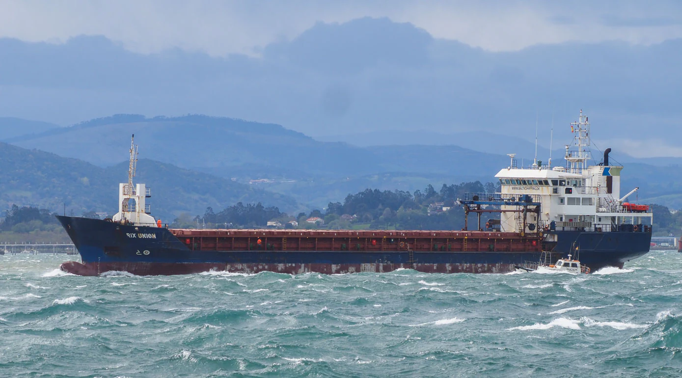 Un carguero en la bahía con el mar picado típico de los días de viento sur.