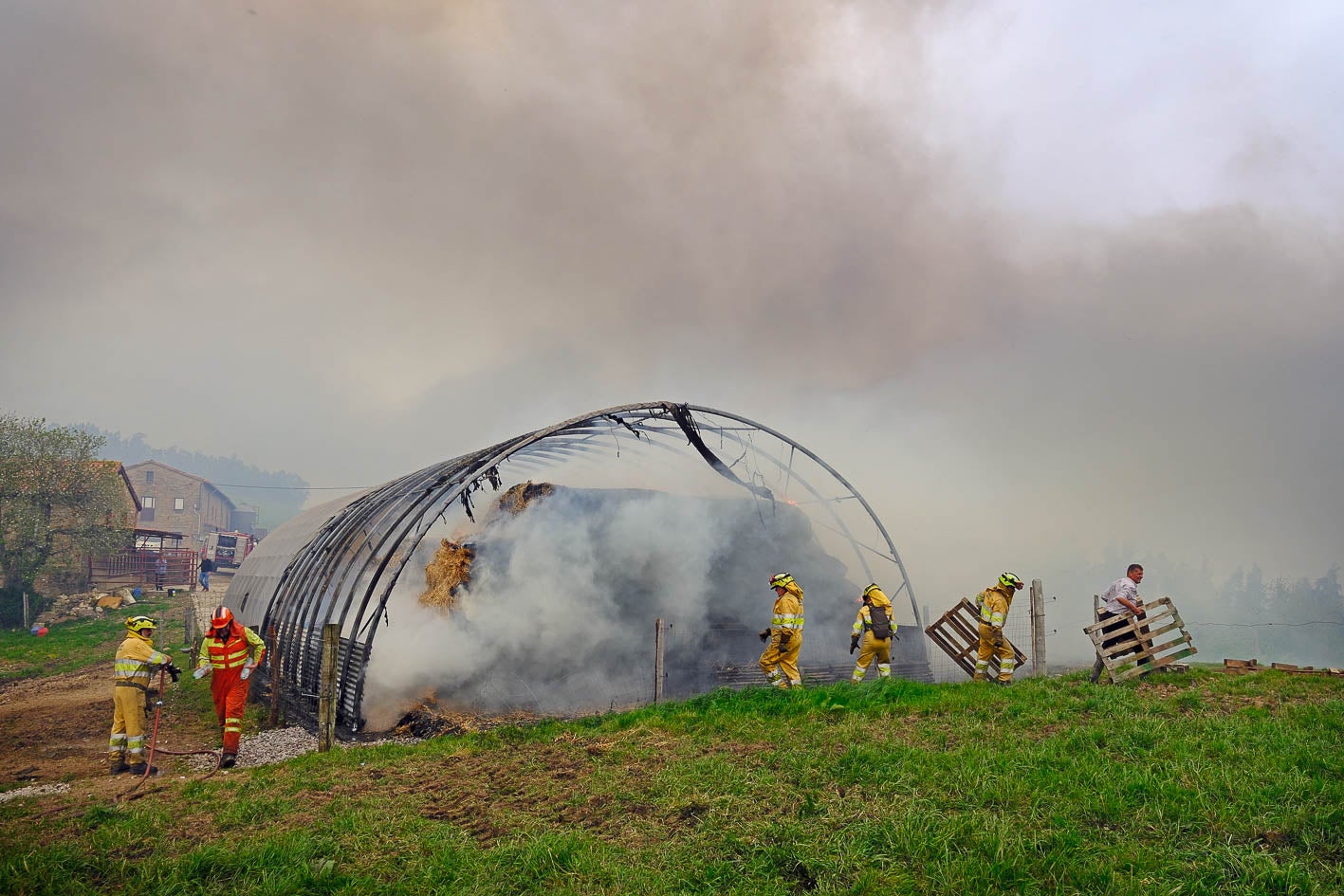 Los bomberos forestales trabajan en la extinción del fuego en la finca de La Busta. 