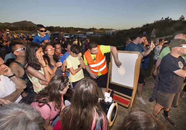 Un grupo observa el eclipse parcial del sol desde el observatorio que montó AstroCantabria en la playa de Liencres en 2017.