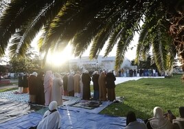 Mujeres (en primer término) y hombres (al fondo) de la comunidad musulmana rezan para despedir la fiesta del Ramadán, este miércoles al amanecer, en el parque Manuel Barquín de Torrelavega.