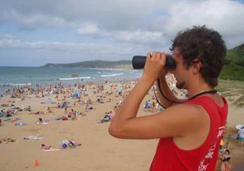 Un socorrista con los prismáticos en la playa de Merón.