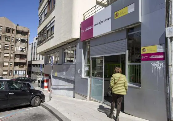 Una mujer se acerca a la entrada de una oficina del Servicio Cántabro de Empleo situada en Santander.