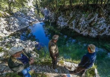 Tres pescadores observan el bajo nivel del río Pas en el coto de Covanchón de la localidad de Puente Viesgo la temporada pasada.