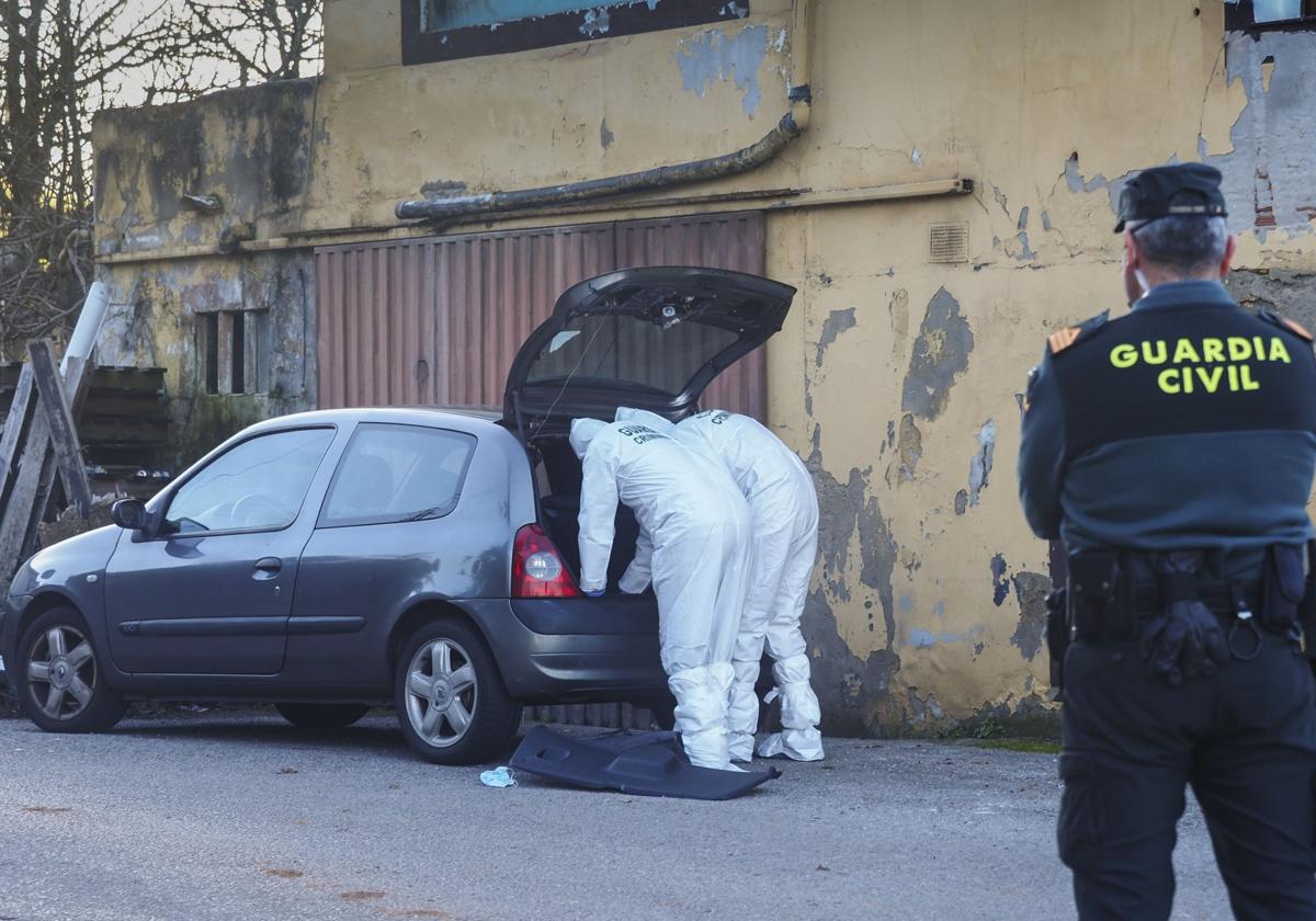 Dos agentes de Criminalística recaban pruebas en un vehículo.