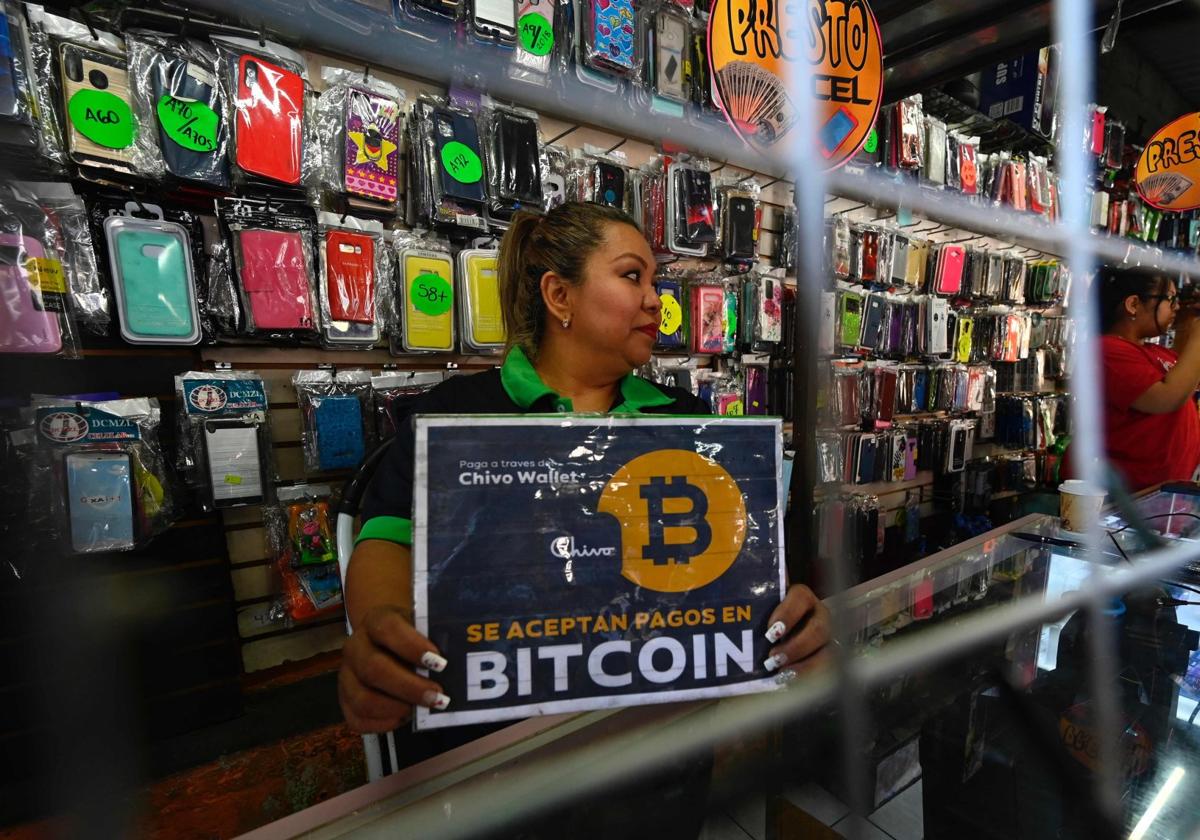 Una vendedora de El Salvador con un cartel que admite el Bitcoin como método de pago.