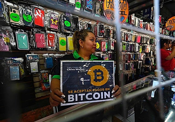 Una vendedora de El Salvador con un cartel que admite el Bitcoin como método de pago.