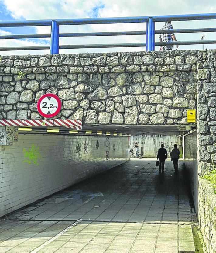 Imagen secundaria 2 - A la izquierda, una mujer atraviesa la carretera a escasos metros de los vehículos. Y, a la derecha, el paso subterráneo que conecta ambos lados de la calle. 