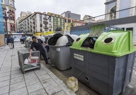 Un trabajador deposita residuos en uno de los contenedores que se encuentran junto al Mercado de Puertochico, algunos de ellos muy deteriorados.