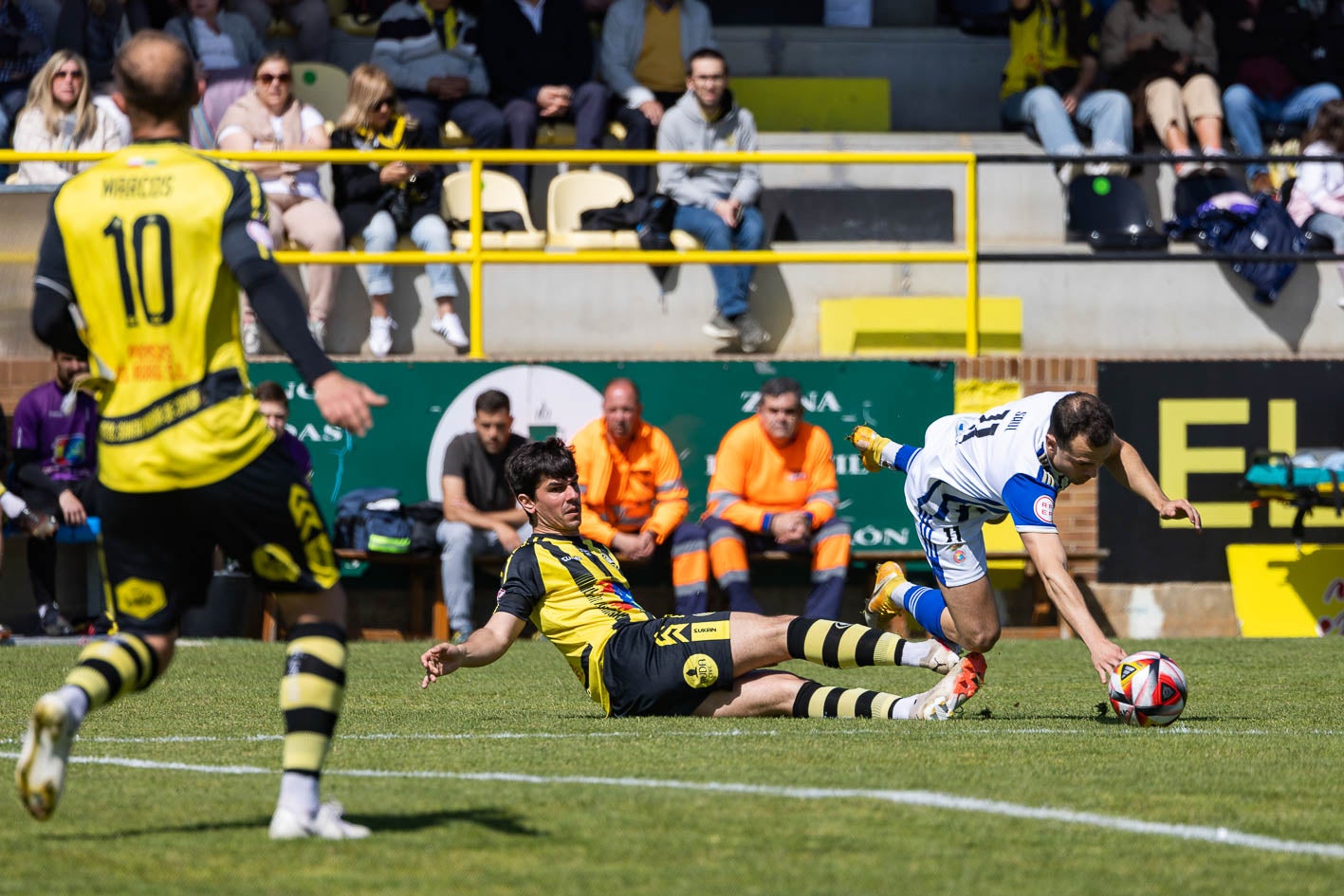 Saúl, de la Gimnástica, a punto de caer al suelo tras una entrada de un jugador del Cayón. 